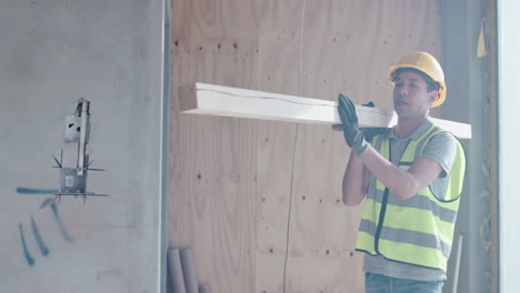 construction worker carrying lumber