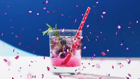 Animation-of-confetti-falling-and-cocktail-on-blue-background