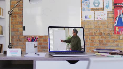 Mixed-race-male-teacher-displayed-on-laptop-screen-during-video-call