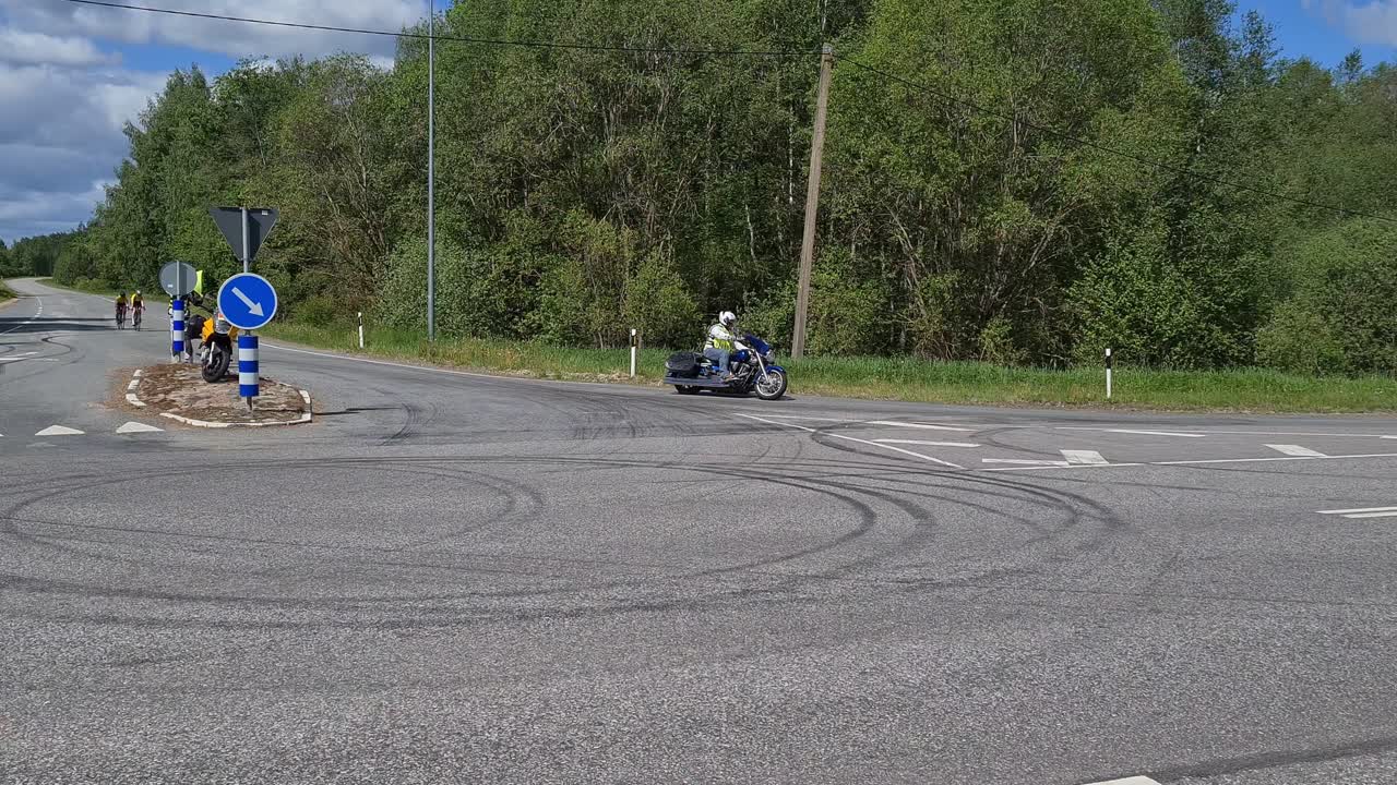 2 cyclists escorted by motorcyclist at bicycle race