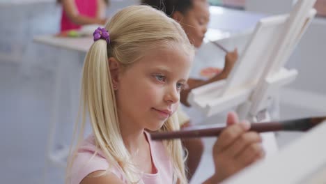 video of focused caucasian girl painting during art lessons at school