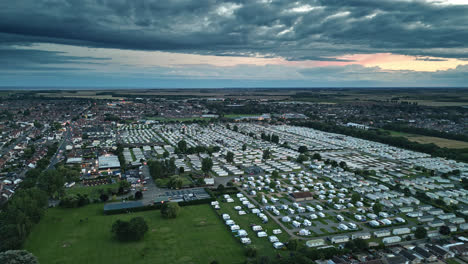 Sunset-drone-footage-captures-Skegness-coastal-charm:-holiday-park,-beach,-caravans,-and-panoramic-sea