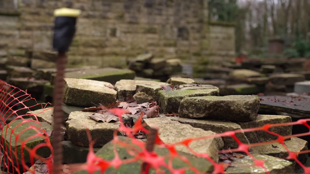 흐린 날 숲 묘지에서 건설 및 개조 중인 묘비 벽돌, 무덤을 보호하는 밝은 울타리