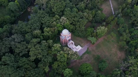 Una-Iglesia-Solitaria-Rodeada-De-Frondosos-Bosques-Al-Atardecer,-Creando-Un-Ambiente-Sereno,-Vista-Aérea