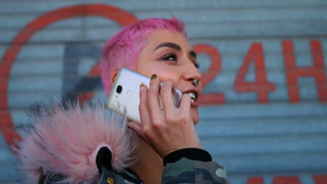 mujer de cabello rosa hablando por teléfono móvil fuera de la tienda 4k