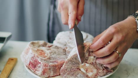 woman doing incisions on beef rolled in flour