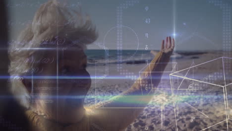 Senior woman raising arm on sandy beach, interacting with floating tech math formulas and hex grid