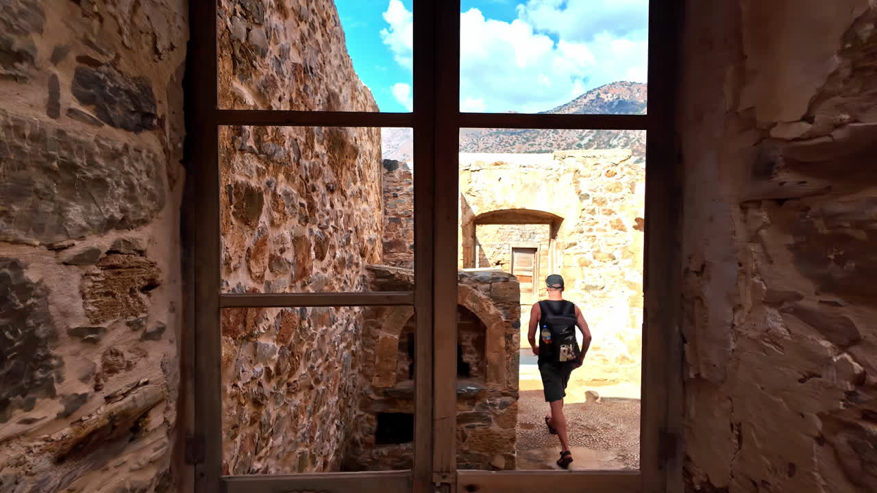 Ancient stone window view on Spinalonga Island showing historic architecture and rustic walls