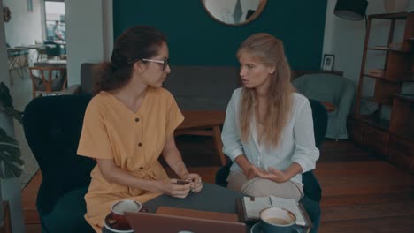 dos mujeres teniendo una conversación en un café