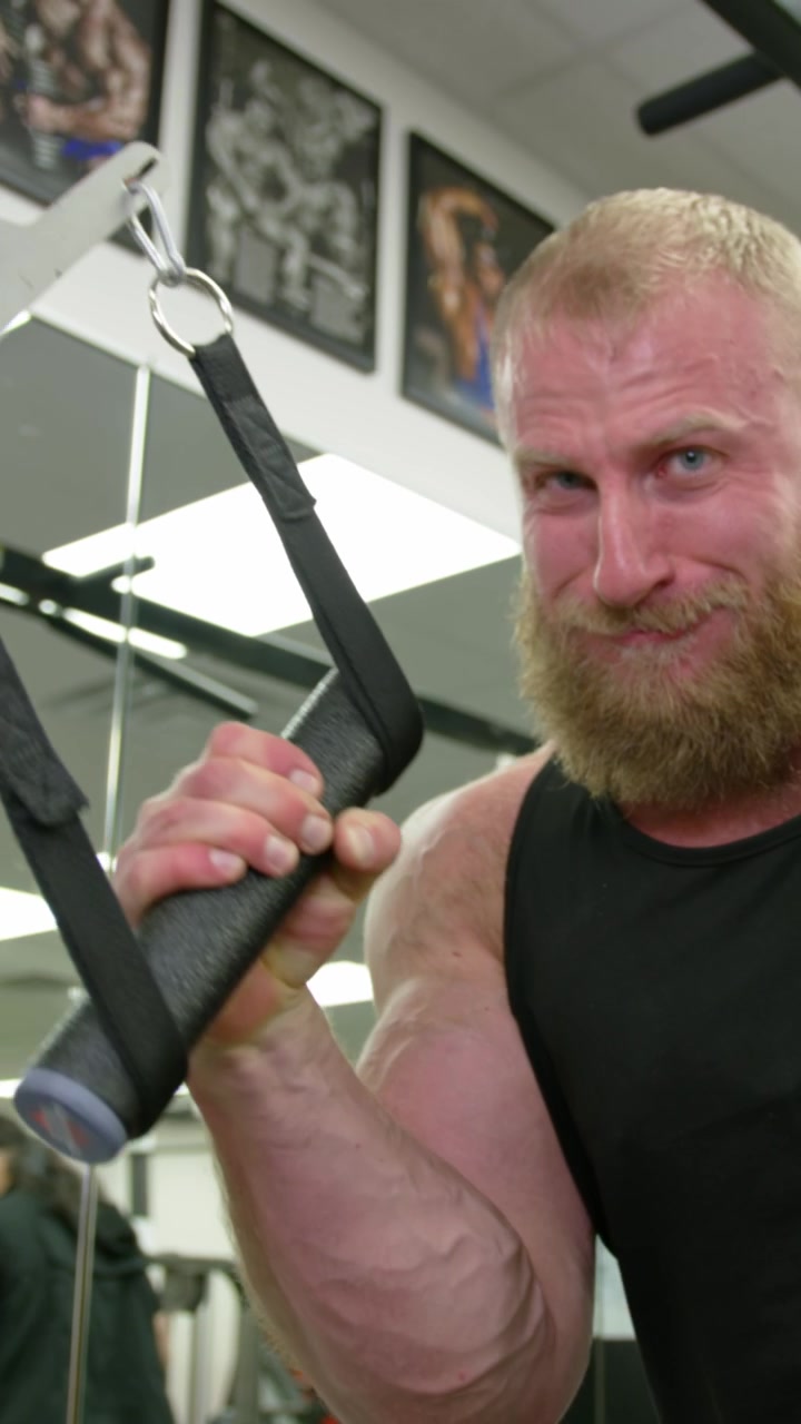 Ung mandlig voksen, der træner hårdt i fitnesscenter