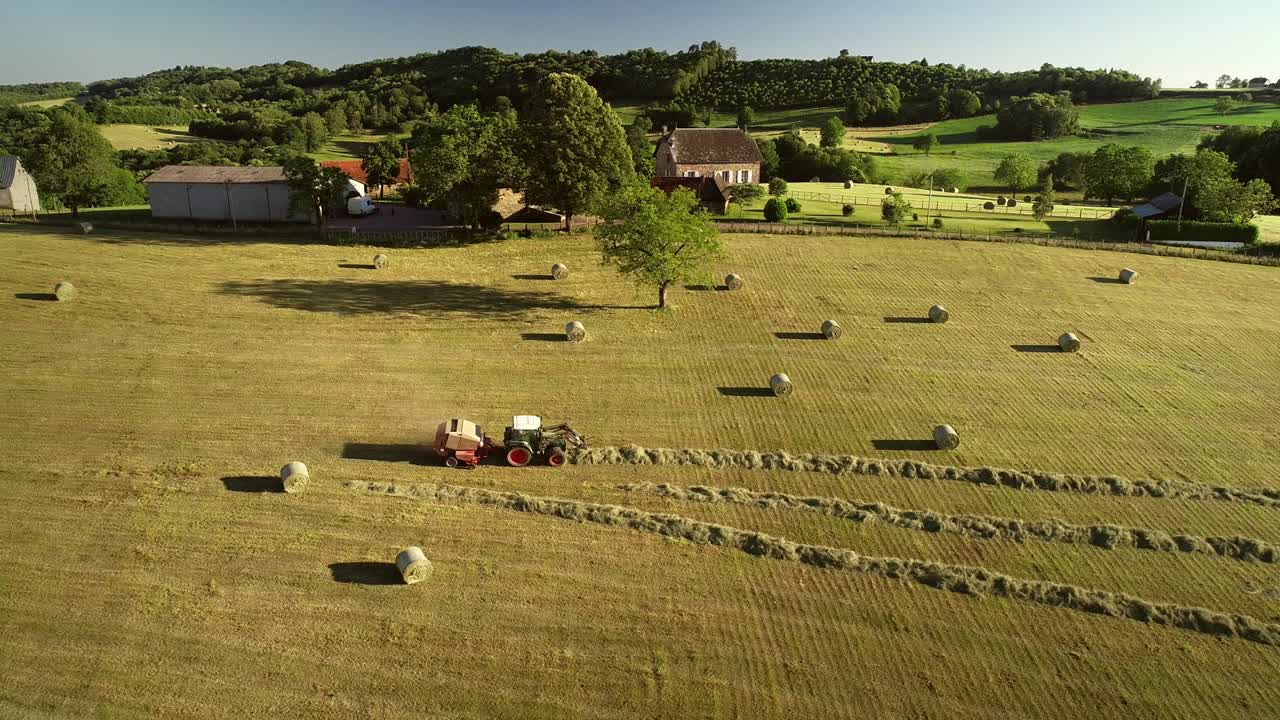 взгляд с воздуха на трактор, собирающий соломенные балы.