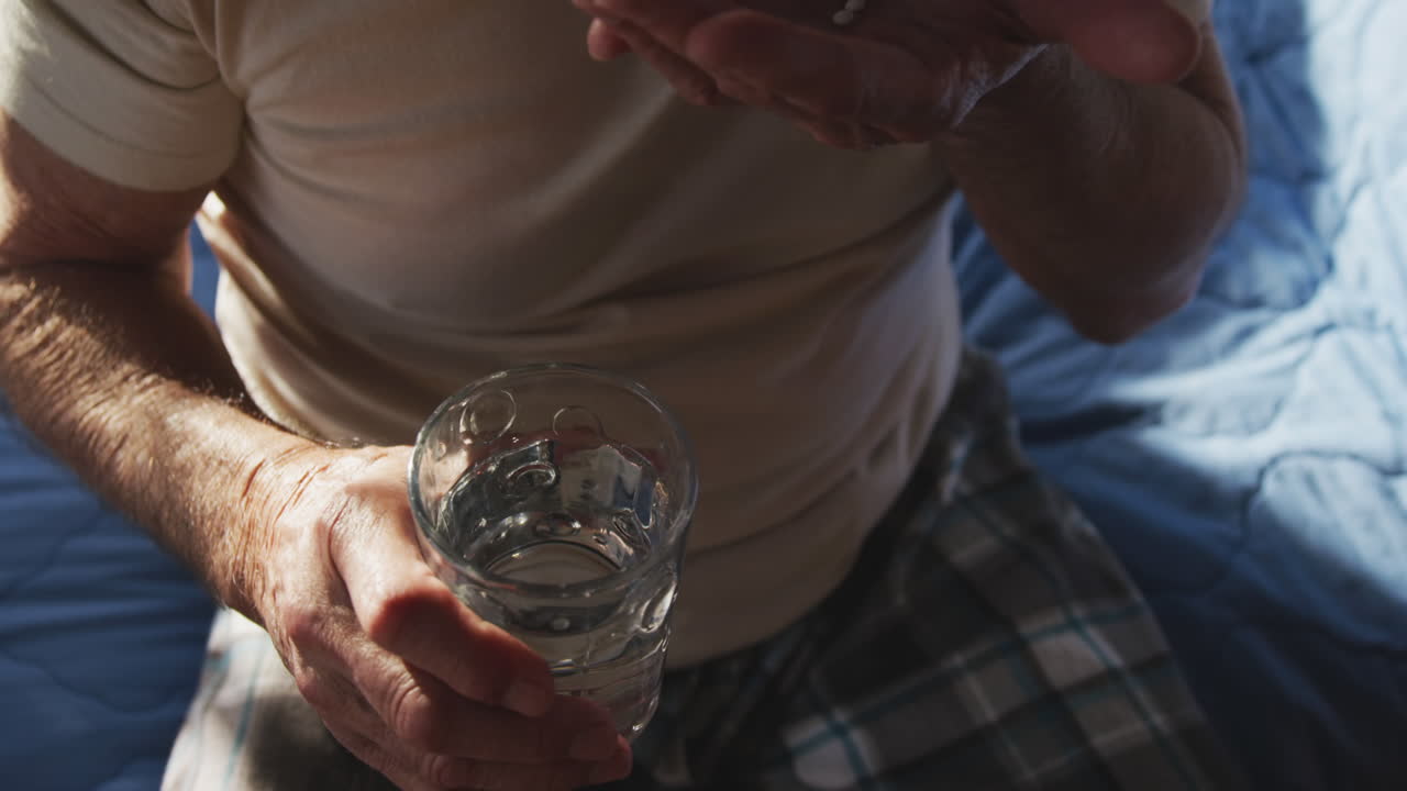 집에 물과 의약품을 가진 노인