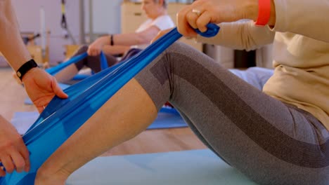 entrenador ayudando a una mujer mayor en la realización de yoga 4k