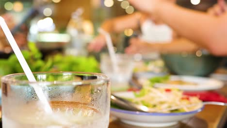 diners enjoy a lively meal in a bustling bangkok restaurant. warm lighting and blurred motion create an energetic atmosphere