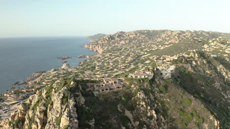 famous-Italian-city-on-mountains-of-Sardinia-island,-aerial-pan-shot