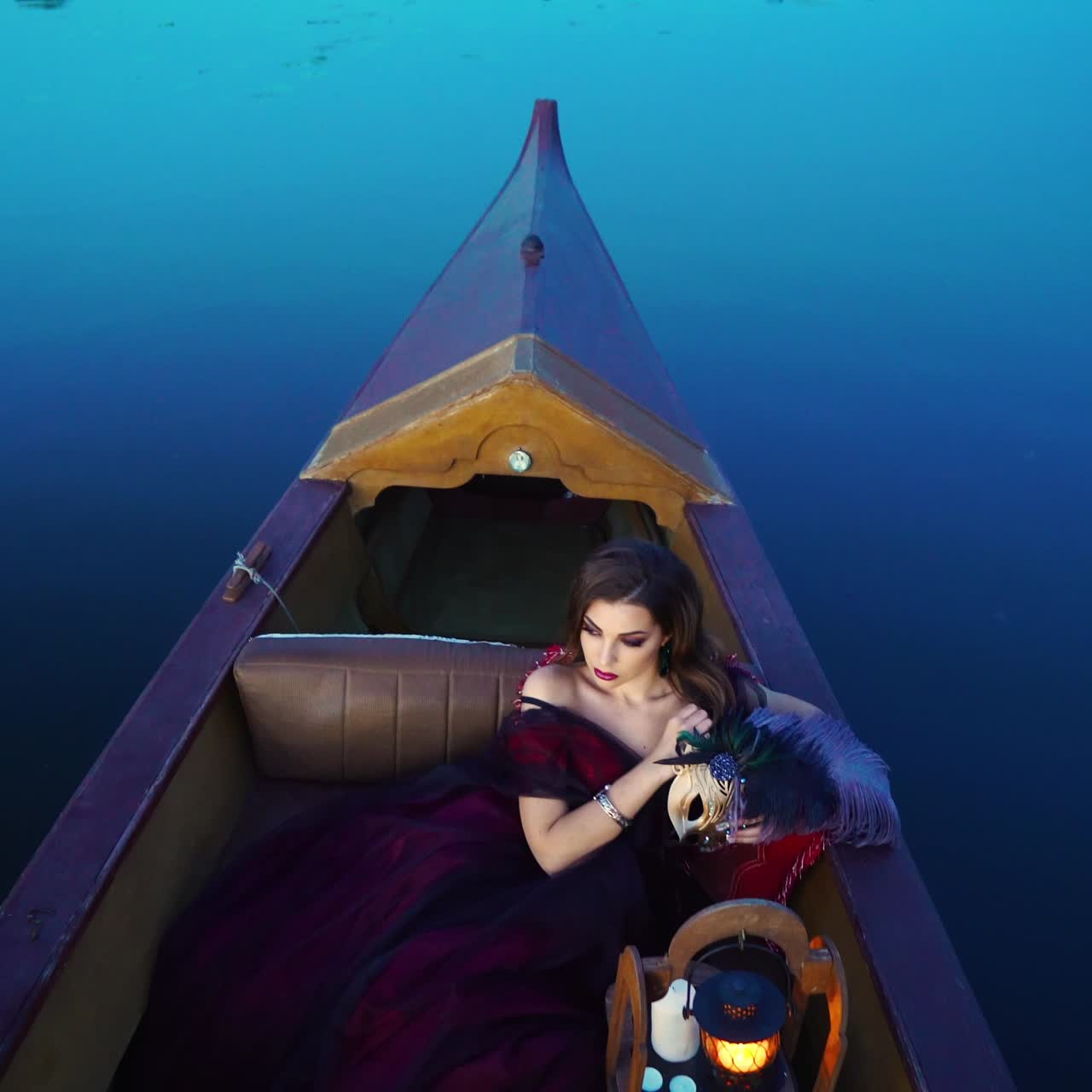hermosa mujer con máscara de carnaval montada en góndola, venecia, italia.
