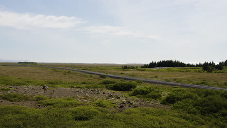 Blue-sky-day-over-deserted-Icelandic-road-in-Snaefellsnes-Peninsula,-Aerial-slide-right,-low-level