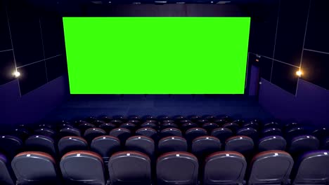 dark empty cinema hall with green screen.