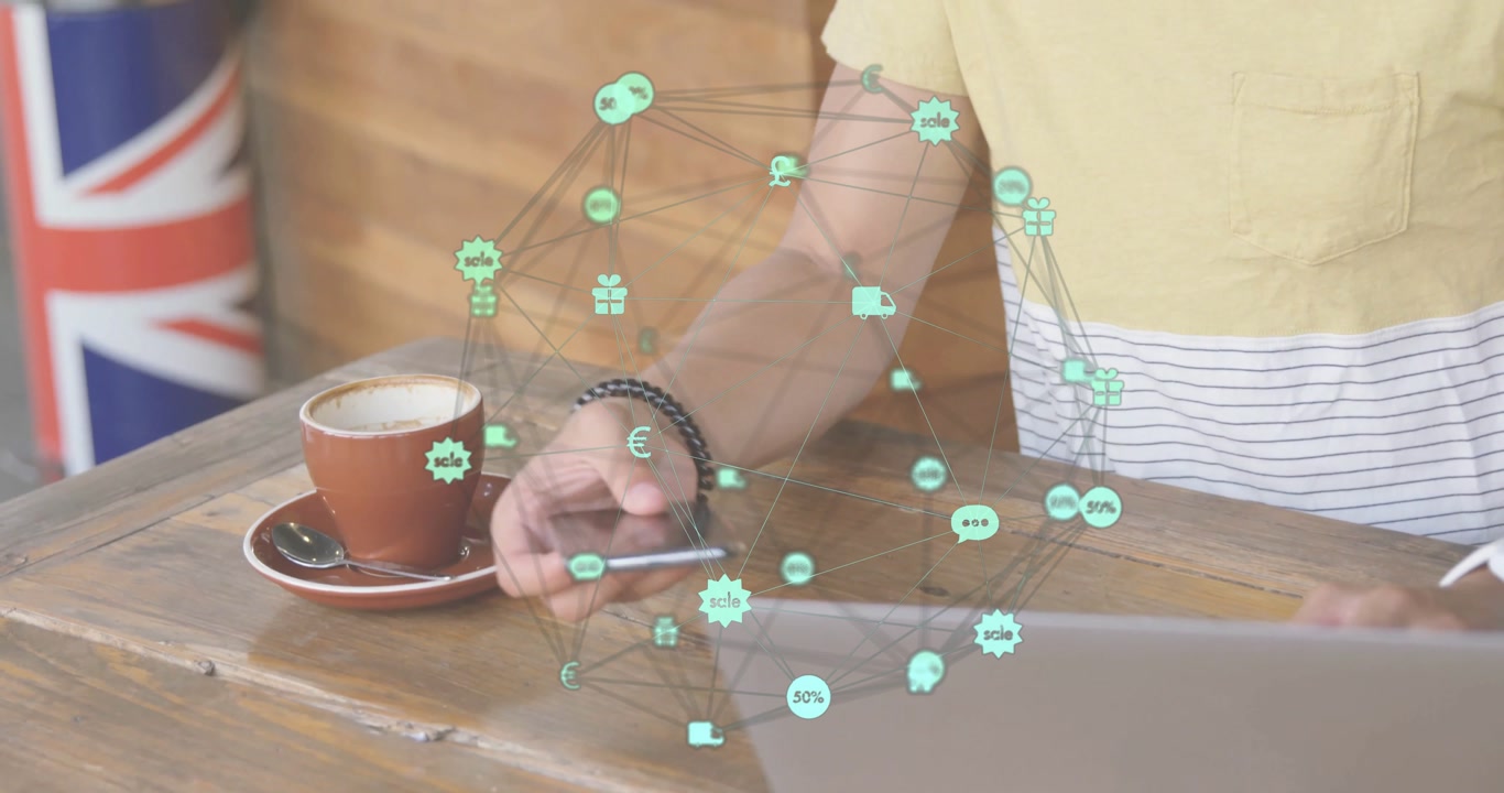 Man tapping smartphone and typing on laptop at cafe table, showing glowing e-commerce icons