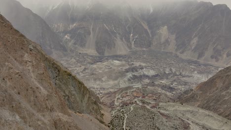 Aerial-view-of-a-desolate-mountain-environment-with-a-cloudy,-overcast-sky-suggesting-a-remote-or-harsh-location