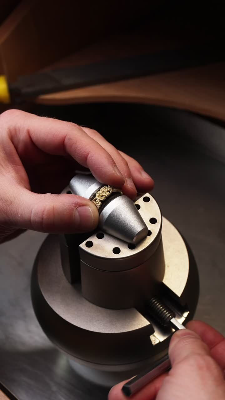Jeweler's Hands Securing an Intricate Gold Ring on a Workbench
