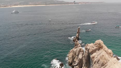 Aerial-View-of-Rock-Formation-Along-Ocean-Coast-With-Boats