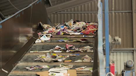 papierabfälle, die auf einem förderband nach oben bewegt werden, um in einer papierrecyclinganlage verarbeitet zu werden