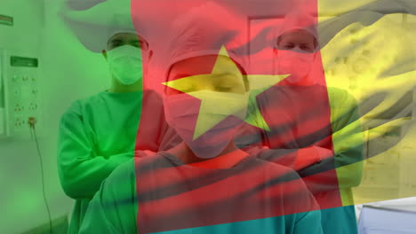 cameroon flag waving against portrait of team of surgeons wearing face masks at hospital