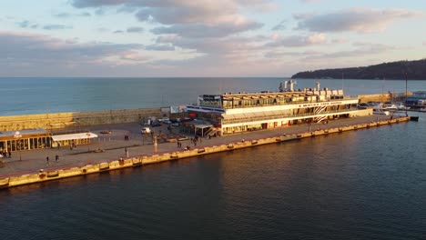 Edificio-En-El-Puerto-De-Varna-Pier-Drone-Disparo-Distancia-Que-Rodea-Durante-La-Puesta-De-Sol