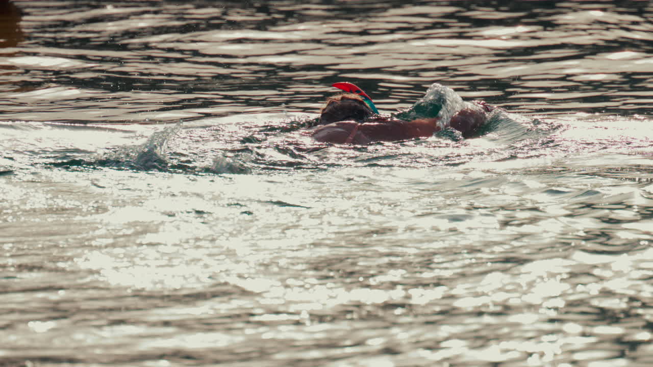 A woman snorkeling in the ocean, floating in gentle water under soft sunlight