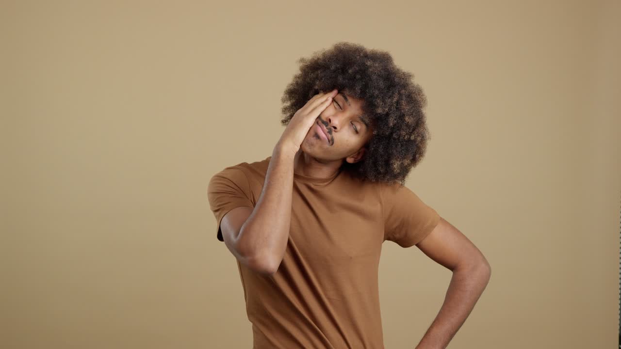 Young man with afro hair expressing various moods in a studio