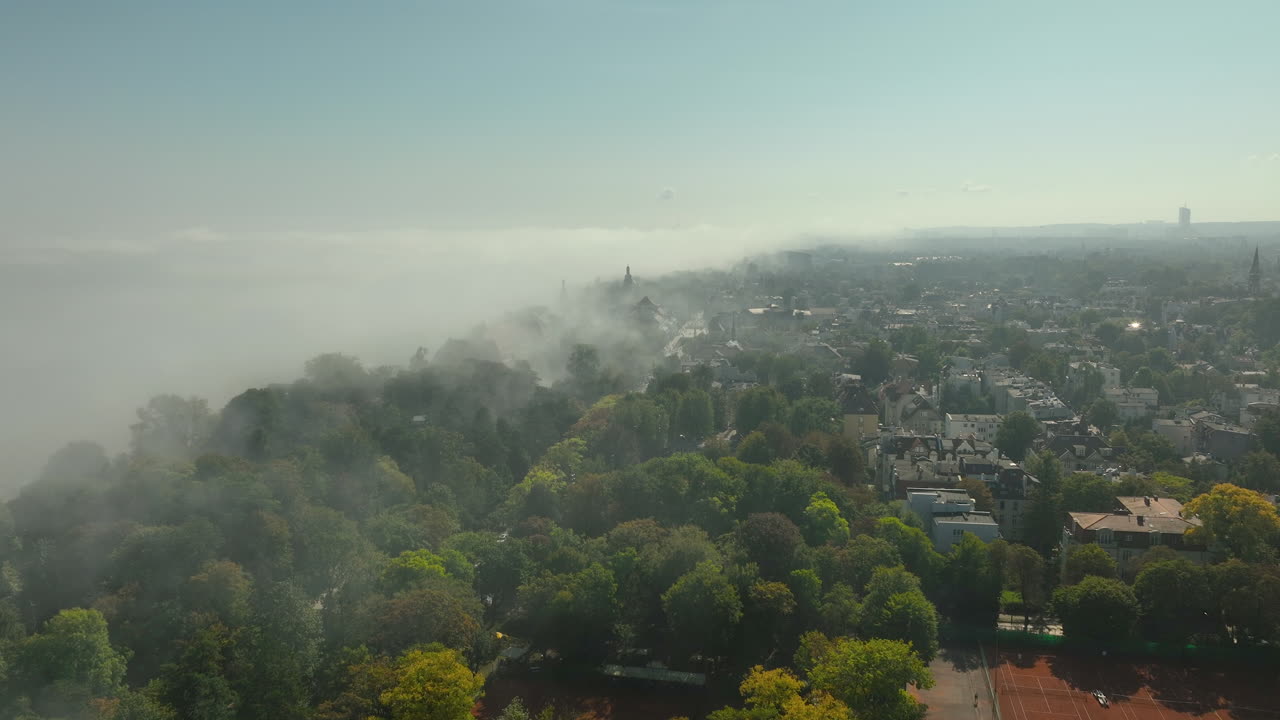 City of Sopot surrounded by fog with green trees and rooftops visible through the mist