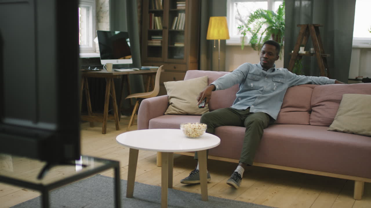 Afro Man With Popcorn Watching TV At Home