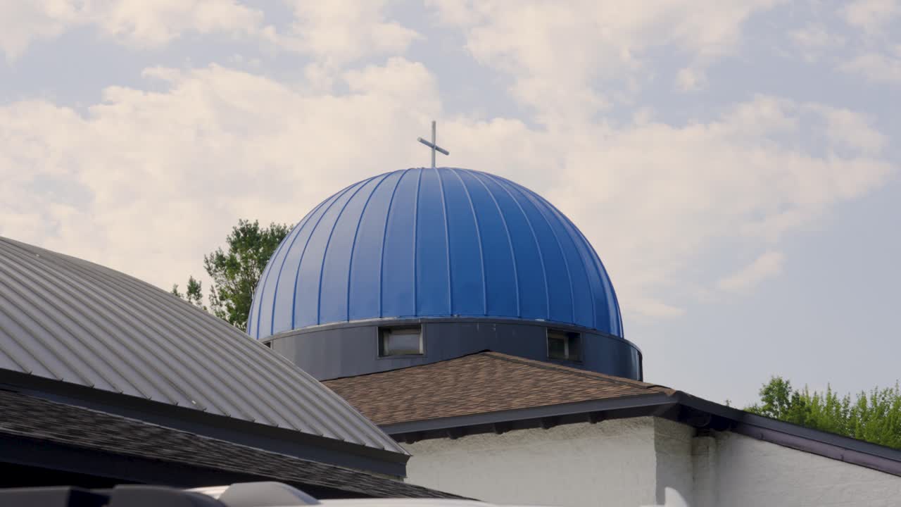 Blue Domed Church with Cross Under Cloudy Sky