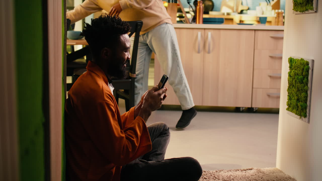 Uomo afroamericano, relax a casa, controlla i messaggi.