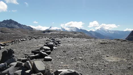 drone flying low over viewpoint of col de l'iseran on sunny summer day, france