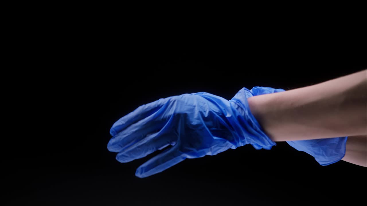 Close-up of doctor hands wearing blue medical gloves for safety protection black background, vaccine against coronavirus, vaccination against covid-19, laboratory research concept