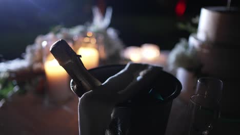 champagne bottle in bucket with glowing candles, creating a romantic evening ambiance