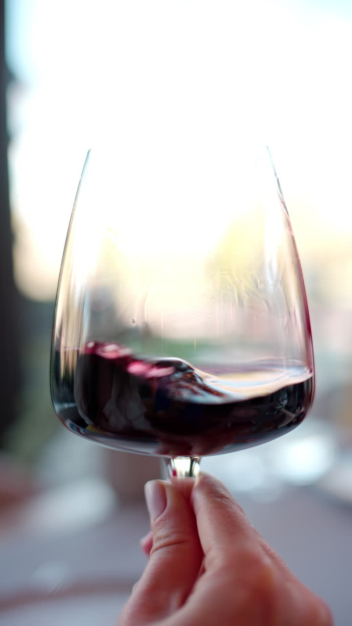 Vino rosso fatto roteare in un bicchiere. Verticale