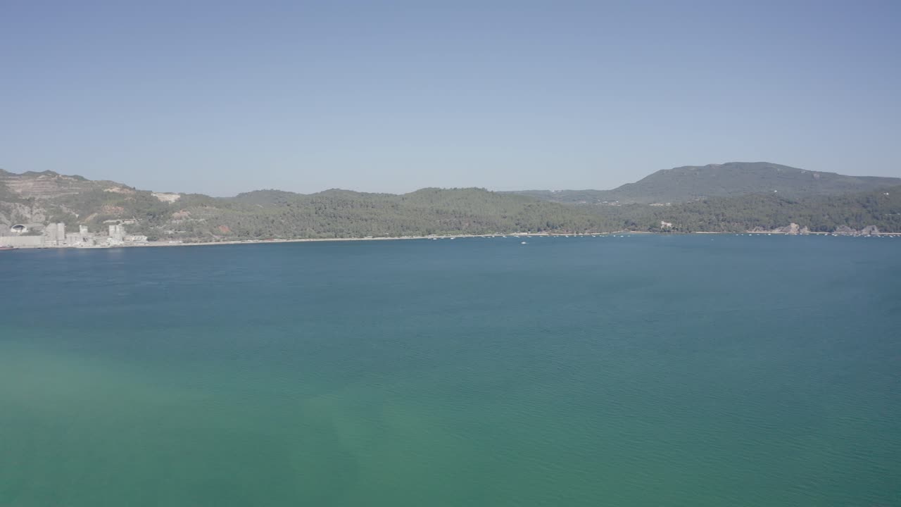 Aerial shot small fishing boats leaving a dock on deep blue Atlantic sea with clear water and blue sky at sunny day