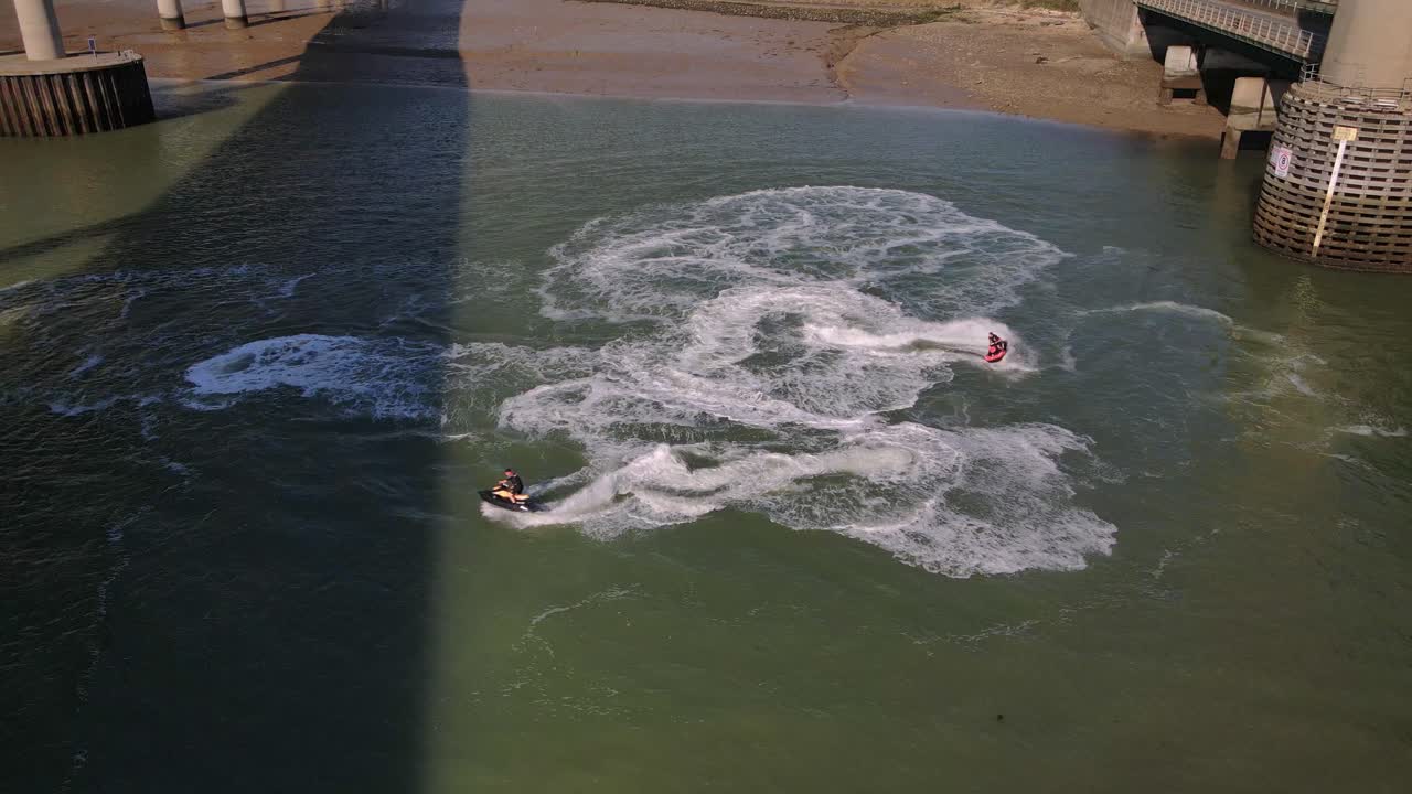 관광객들은 킹스페리 다리와 셰피 교차로 사이의 수경에서 제트스키 운전을 즐깁니다.