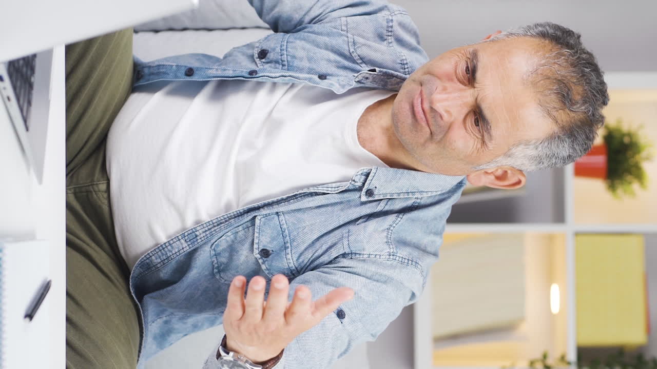 Vertical video of The man who can't use the application on the laptop.