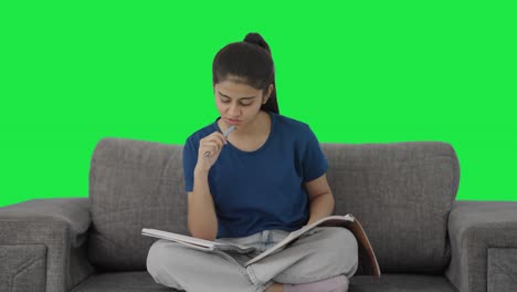 una adolescente india confundida preparándose para los exámenes pantalla verde