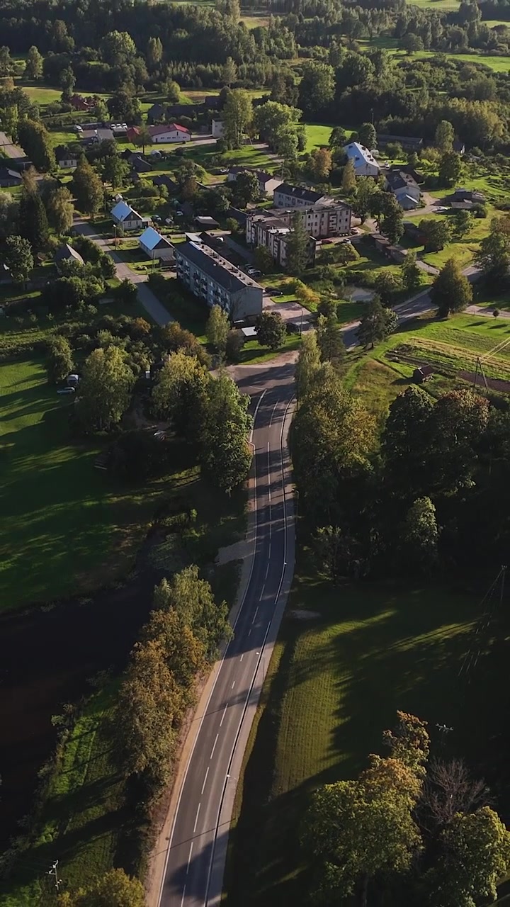 Ascesa verticale di drone sopra la splendida e verde campagna, il centro del villaggio della parrocchia di Nitaure, Municipalità di Cesis, Regione di Vidzeme, Lettonia