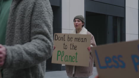 Young-Female-Activist-Holding-A-Cardboard-Placard-And-Protesting-Against-Climate-Change