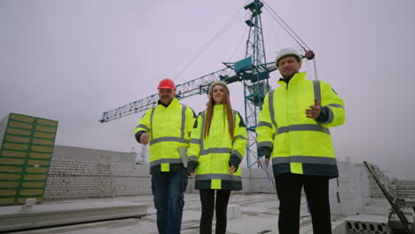 tres inspectores de construcción están caminando en el sitio de construcción arquitectos femeninos y ingenieros civiles masculinos