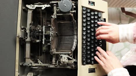 manos de un escritor nostálgico usando una máquina de escribir antigua