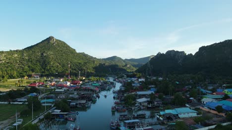 Aerial-footage-sliding-to-the-left-revealing-a-boat-coming-down-and-this-picturesque-fishing-village