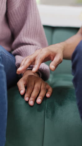 vertical video of hands of african american couple touching