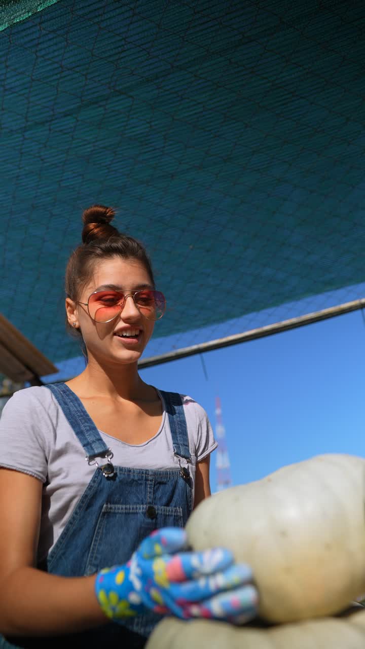mujer recogiendo calabazas en un mercado agrícola